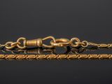 a close up of a gold chain on a black surface