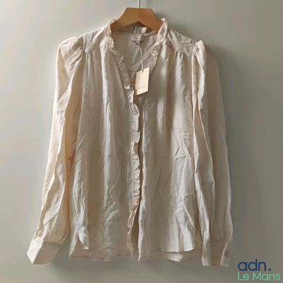 the shirt is hanging on a hanger on the wall