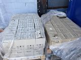a pile of boxes sitting on a pallet next to a blue trash can
