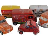 Plusieurs petites voitures et camions sont alignés sur une surface blanche