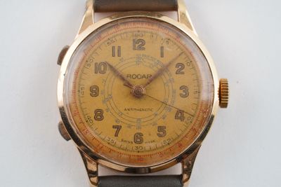 une montre-bracelet en or avec un bracelet en cuir brun