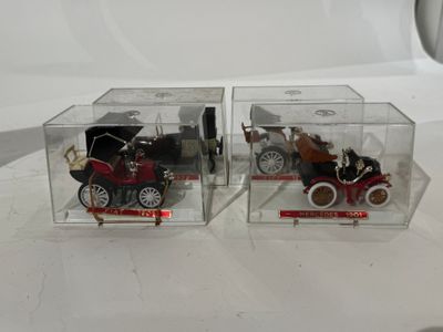 deux petites voitures miniatures dans une boîte transparente posée sur une table