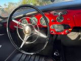 tableau de bord d'une voiture rouge équipée de sièges et d'un volant en cuir noir