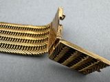 an image of a close up of a gold bracelet on a table