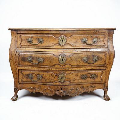 une vieille commode en bois avec des sculptures ornementales sur les tiroirs