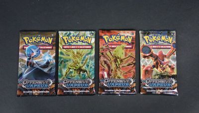 trois paquets de cartes à collectionner Pokémon posés sur une table