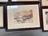 many framed pictures on the wall of a room