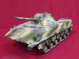 a toy tank that is sitting on a red surface