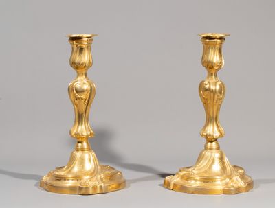 pair of antique brass candlesticks on stand on grey background