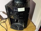 a black coffee maker sitting on top of a wooden table