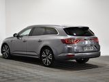 the rear end of a silver car parked in a white room