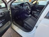 a white car with its door open sitting in a parking lot