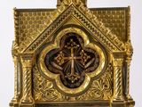 a gold clock with a cross on the top of it