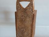 un petit porte-monnaie en bois exposé sur une étagère vitrée