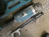 a drill and a hammer on the ground next to a pair of shoes