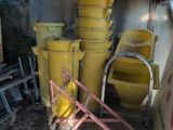 many yellow buckets sitting in the corner of a building