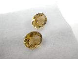 two yellow sapphires sitting on top of a white surface