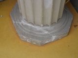 a close up of a white pillar on a yellow table
