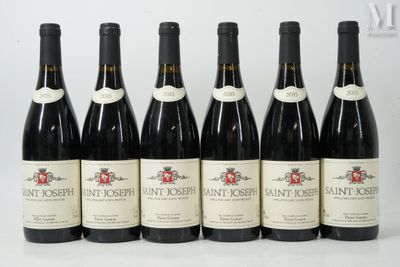 six bouteilles de vin sont alignées sur une table