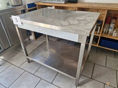a stainless steel table in the middle of a kitchen