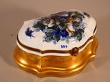a white and gold box with blue flowers on it