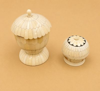 un petit vase blanc et un autre petit vase blanc posés sur une surface marron