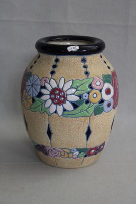 un vase orné d'un motif floral, posé sur une table
