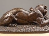 bronze statue of a woman laying on her back on a wooden table