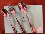 two forks and two spoons sitting on a box on a table
