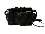 a black camera that is sitting on a white surface
