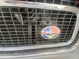 the front grill of a car with an american flag emblem on it