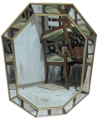 a mirror with a chair and a chair in front of it