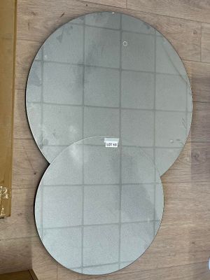deux miroirs ronds accrochés au mur au-dessus d'un lavabo