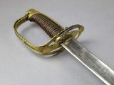 a close up of a sword on a white surface
