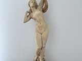 a statue of a woman holding a bird on top of a table