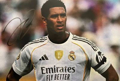 photo dédicacée d'un footballeur en maillot blanc devant une foule