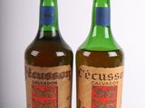 two bottles of alcohol sitting next to each other on a white surface