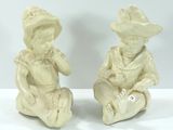 deux figurines représentant un garçon et une fille assis par terre