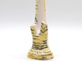 a yellow vase with a black and white design on it