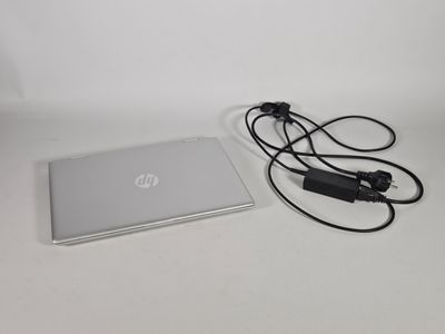 un ordinateur portable et un chargeur posés sur une table