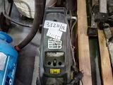 a machine that is sitting next to a pile of wood
