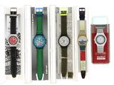 cinq montres différentes dans une vitrine sur fond blanc