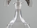 a clear glass bottle with a silver handle on a table