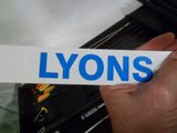 une personne tenant un bout de papier sur lequel est écrit « Lyon »