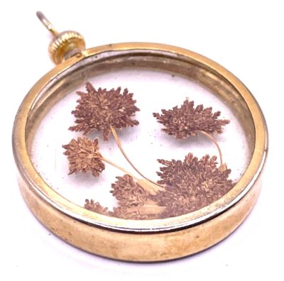 a picture of a flower inside of a glass pendant
