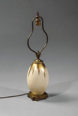 une lampe à l'ancienne, dotée d'un abat-jour en verre blanc posé sur un socle en bois