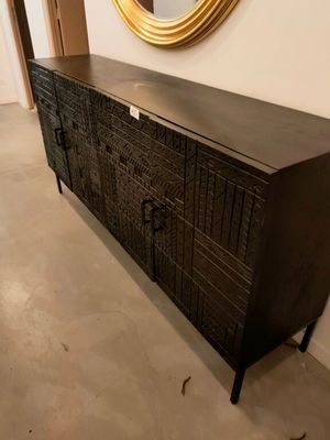 une commode noire surmontée d'un miroir