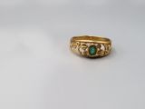 a close up of a gold ring with a green stone in the middle