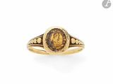 une bague en or sur laquelle sont gravés le visage d'une femme et celui d'un homme