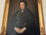 portrait of a woman in a black dress with a green shawl in a gold frame